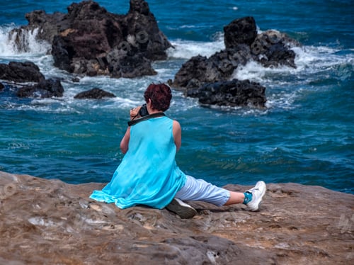 Preview: Woman photographer sits to photograph the Pacific Ocean seascape