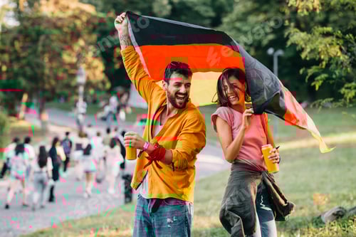 Preview: Young couple dancing at a festival in the park with a german flag