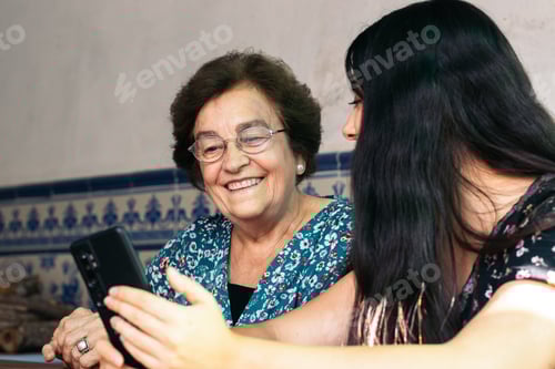 Visualização: Jovem mulher usando smartphone com sua avó