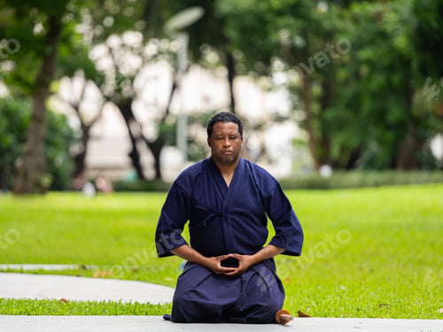 Preview: Handsome black martial artist man with martial arts costume of kendo doing meditation