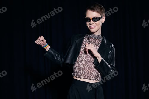 Preview: Positive and stylish mhomosexual man in sunglasses, leather jacket and blouse with animal print