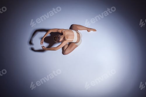 Preview: Young Beautiful Dancer In Beige Swimwear Dancing On Lilac Floor Background