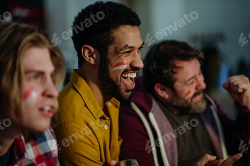 Preview: Happy Austrian football fans friends watching football at home and celebrating