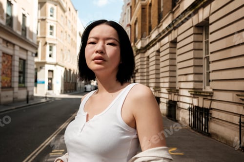 Preview: Young asian woman posing on a london street