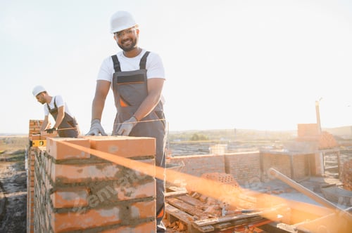 Los trabajadores de la construcción indios trabajan en la construcción de una casa de ladrillo. Construcción de una pared de ladrillos