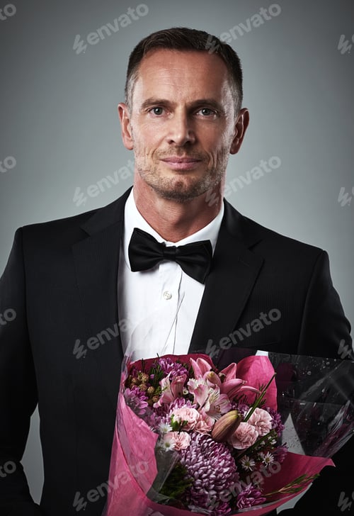 Preview: Hes an old-fashioned suitor. Portrait of a well-dressed man holding a bouquet of flowers.