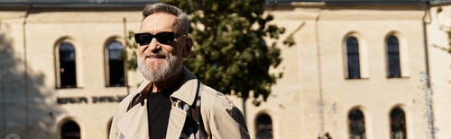 Preview: A debonair senior man strolls through a vibrant cityscape, showcasing his trendy outfit.