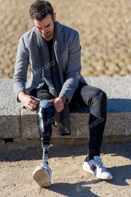 Preview: Young man missing a leg putting on a prosthetic leg