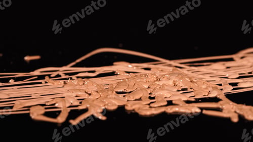 Preview: Close up view of beige and brown makeup foundation on black background