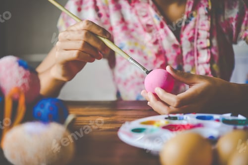 Preview: young girl painting Easter eggs for eastertime at home