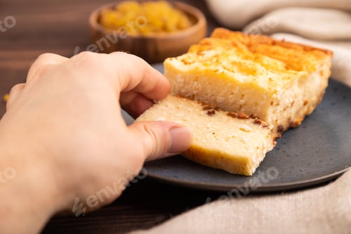 Preview: Сottage cheese Сasserole, Curd cake, with dried apricots and raisins with hand on brown wooden