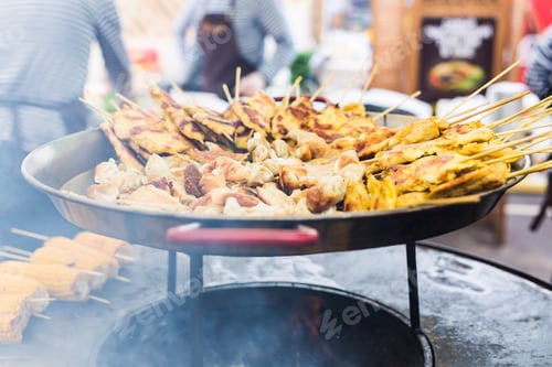 Preview: Grilled chickens inserted on wooden skewers was putting on street shop shelf with many stuffs