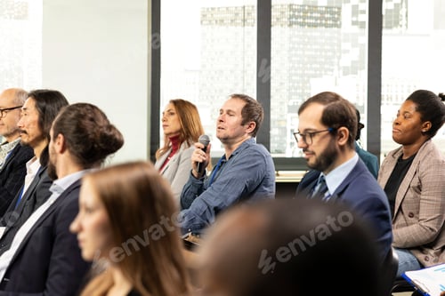 Preview: Adult businessman engaging in analytical discussion during conference