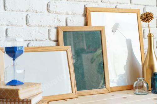 Preview: Wooden frame mockup on table with modern vase and books