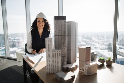 Preview: Young female engineer in white helmet working on building complex prototype project