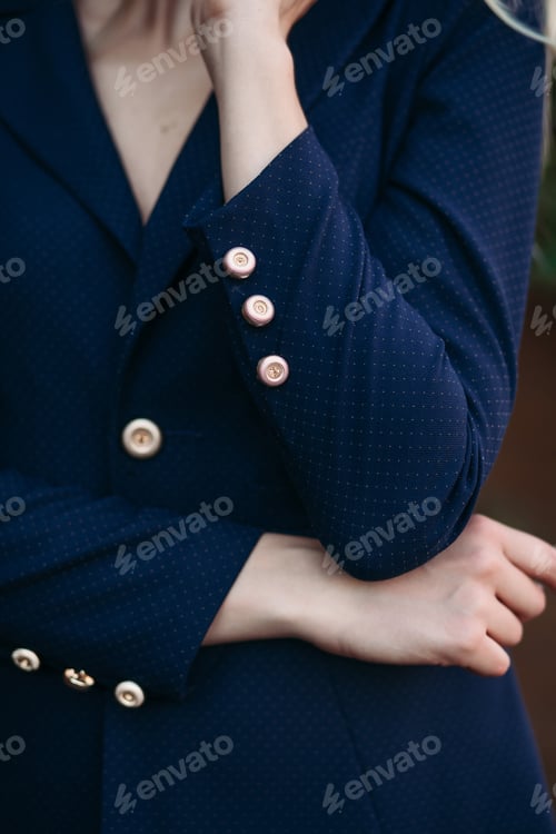Preview: Elegant blonde woman in dark blue suit with gold buttons
