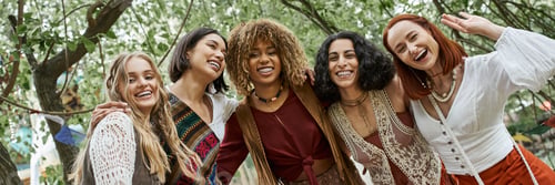 Preview: cheerful interracial women in boho styled clothes looking at camera in retreat center, banner