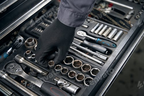 Preview: Mechanic chooses instruments for car repair at work