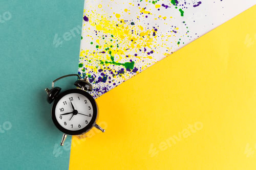 Preview: Vintage alarm clock on a creative colorful background with paint sprinkles