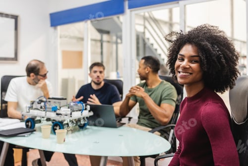 Preview: Robotics engineers working on project in modern office, woman smiling at camera