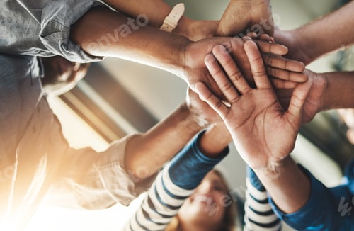 Preview: The dream team. Shot of a group of creative businesspeople standing with their hands in a huddle.