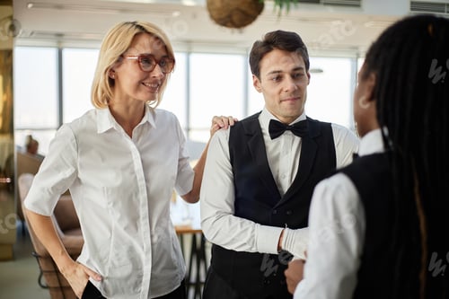Preview: Caucasian Middle Aged Woman and Young Adult Man Supervising Black Woman