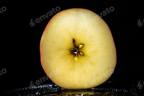 Preview: half of ripe apple on black background
