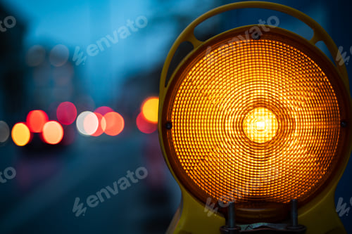 Preview: Closeup shot of yellow light in the dark surrounded by cars