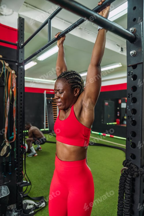 Preview: Black bodybuilder athlete in a sports gym doing a barbell back exercise