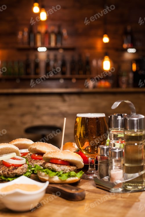 Preview: Cold beer with classic burgers on a restaurant wooden table