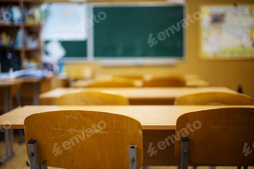 Preview: Classroom with empty chairs and blackboard in the background, shallow depth of field