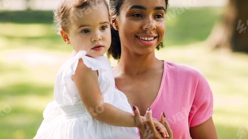 Preview: Portrait of a smiling mother and her little daughter outdoors