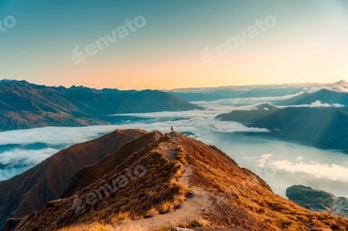 Preview: Female tourist hiking on Roys Peak summit mountain with foggy in the morning at New Zealand