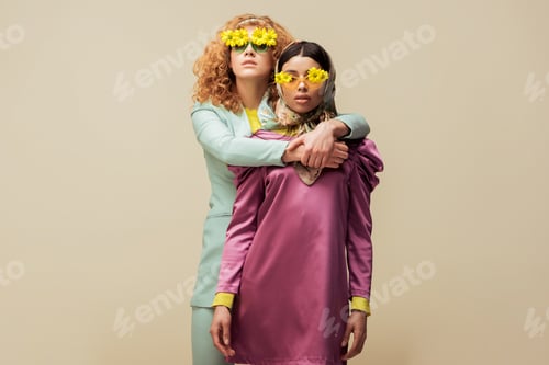 Preview: attractive redhead woman in sunglasses with flowers hugging trendy african american girl isolated on