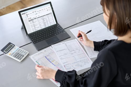 Preview: Asian woman preparing tax return documents