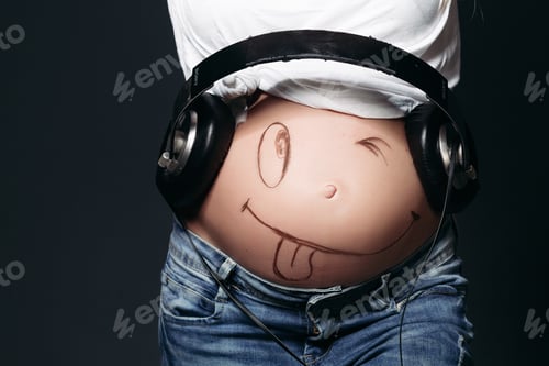 Preview: Pregnant female with big earphones on tummy