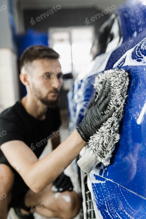 Preview: Manual foam car washing in auto detailing service with microfiber glove by worker