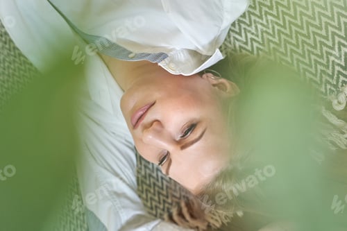 Preview: Relaxed caucasian female lying on zigzag pattern rug with green leaves