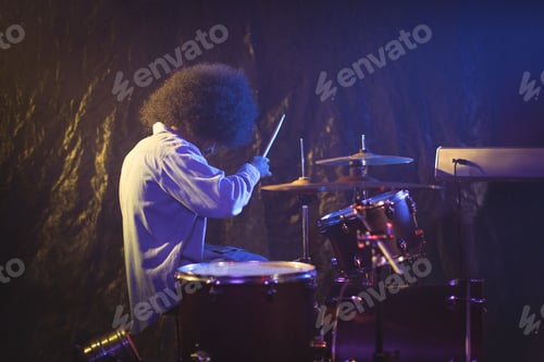 Preview: Male drummer with frizzy hair playing drum kit in nightclub