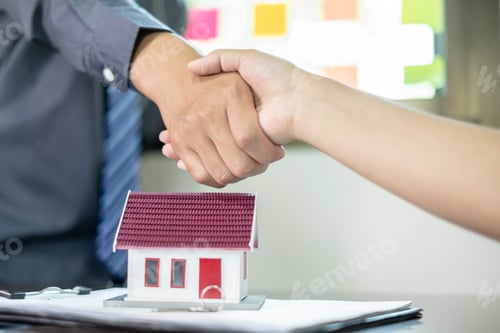 Preview: Businessmen and brokers real estate agents shake hand after completing negotiations to buy house ins