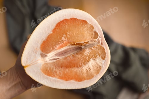 Preview: Ripe pomelo fruit on in hand top view. Incision fruit