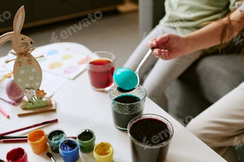 Preview: Child Coloring Easter Egg with Paints during Holiday Preparation