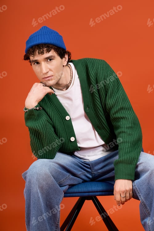 Preview: Captivating man showcasing trendy style against a vibrant orange backdrop