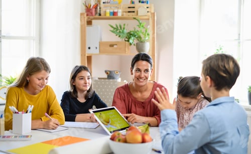 Preview: Group of homeschooling children with teacher studying indoors, coronavirus concept.