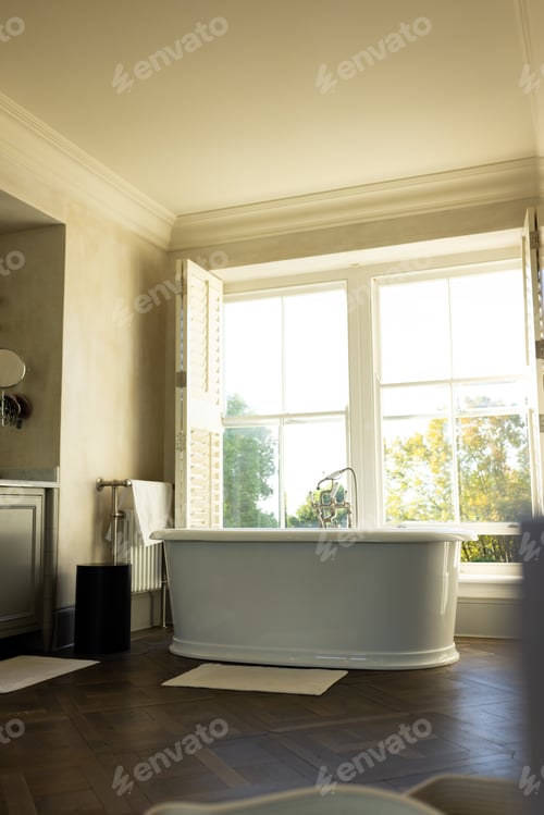 Preview: Bathtub in luxurious bathroom with large windows and natural light