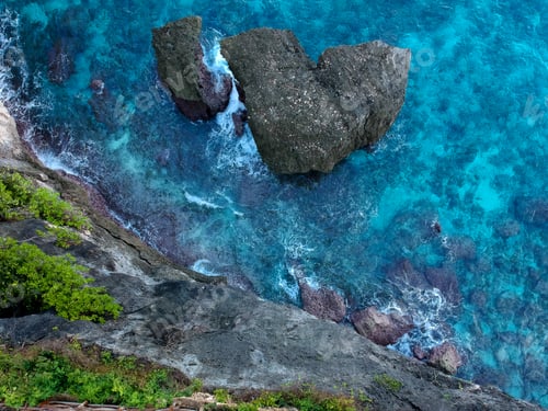 Preview: Aerial view Top down seashore. Waves crashing on rock cliff. Beautiful dark sea surface in sunny day
