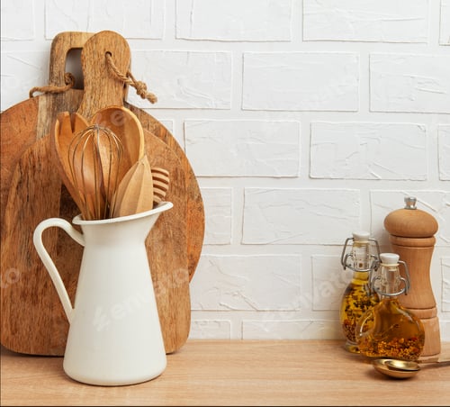 Preview: Kitchen utensils resting on wooden countertop by white brick wall