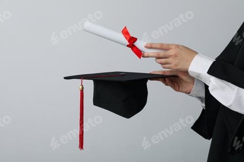 Preview: Diploma and hat of a university graduate, on a gray background.