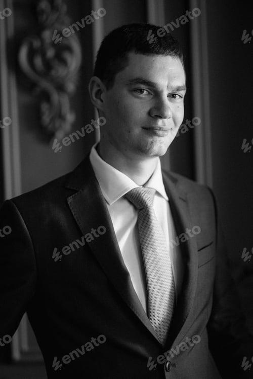 Preview: portrait of groom in blue three piece suit with tie on wedding day