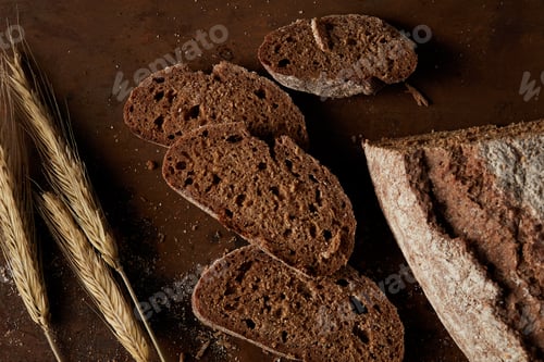 Preview: top view of slices of bread and wheat on brown rusty metal table